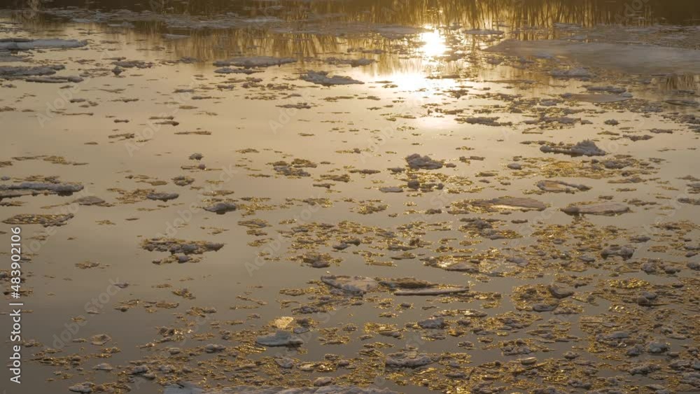 Ice drifting on the Volga river in spring, sun reflecting in water - ice floes floating on water in April at sunset. Natural, abstract, springtime, seasonal and environment conept Ice drifting on the Volga river in spring, sun reflecting in water - ice floes floating on water in April at sunset. Natural, abstract, springtime, seasonal and environment conept