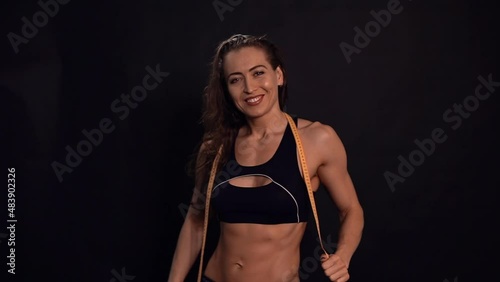 Portrait of an atlitic attractive girl on a black background. Sports lifestyle concept.