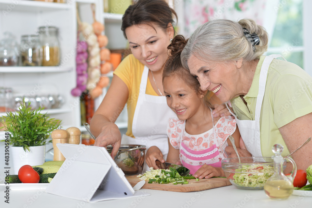 Portrait of happy family coocking salad at kitchen