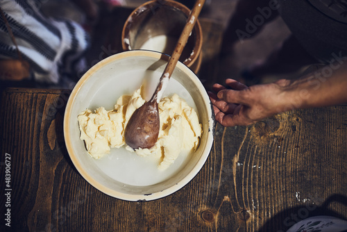 Female making butter with butter churn. Old traditional method making of butter photo