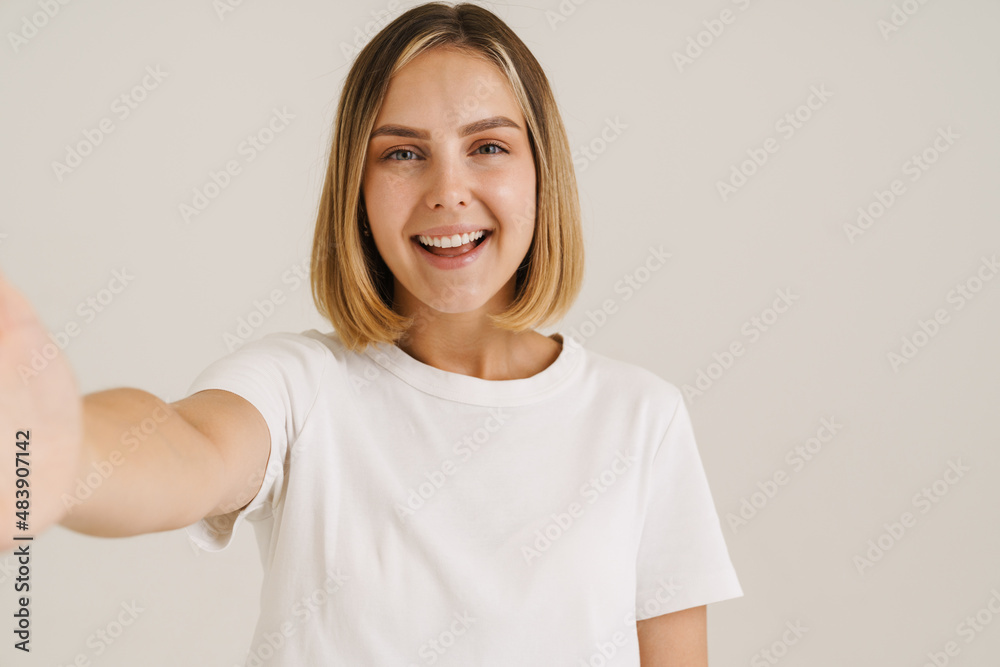 Young blonde woman smiling while taking selfie photo Young blonde woman smiling while taking selfie photo