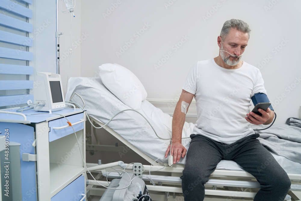 Male patient staring at smartphone during treatment procedure Male patient staring at smartphone during treatment procedure