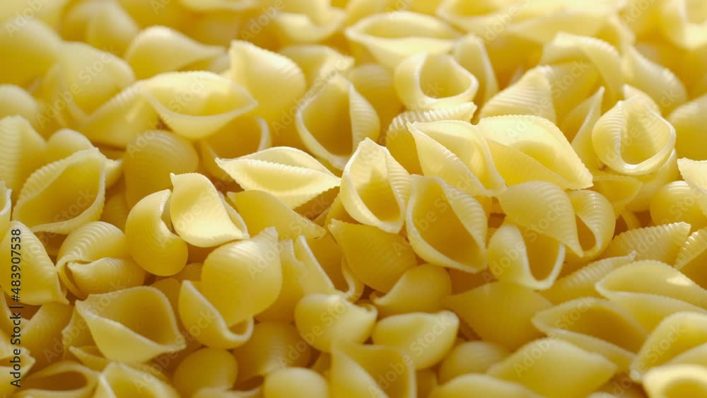 Pasta conchiglie.Pasta for food, rotation. Macaroni - Mini Conchiglie Rigate close up.Shell pasta Pasta conchiglie.Pasta for food, rotation. Macaroni - Mini Conchiglie Rigate close up.Shell pasta
