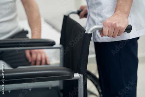 Physical therapist showing wheeled chair to patient
