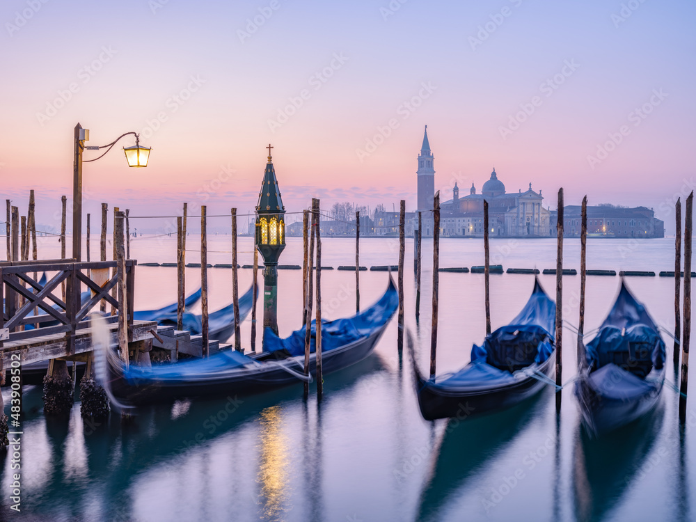 View of San Giorgio Maggiore island at sunrise with gondolas in the ...