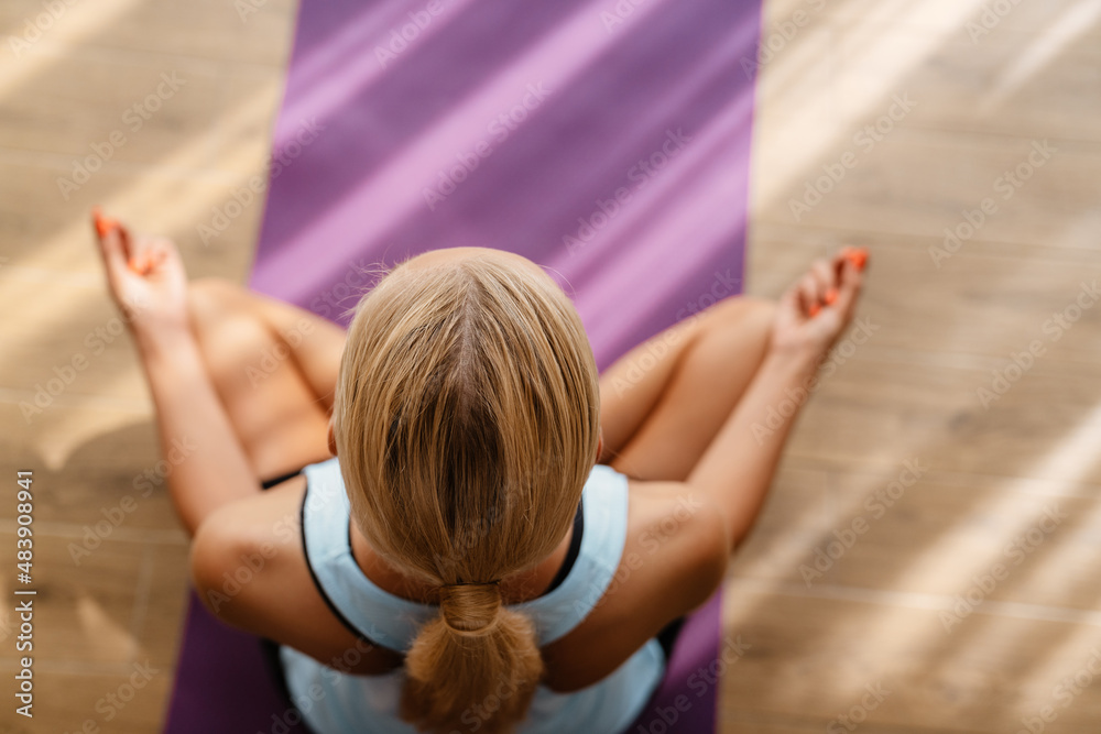 Fototapeta premium Blonde woman meditating during yoga practice at home