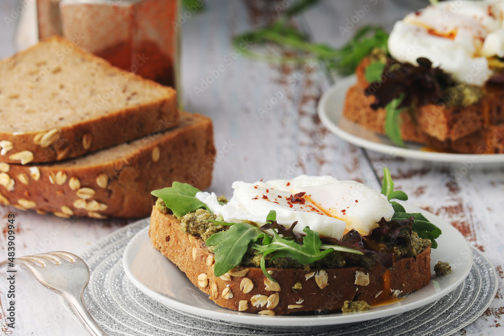 Homemade sandwiches with pesto, green salad and poached eggs	