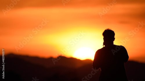 silhouette photographer man with sunset background.