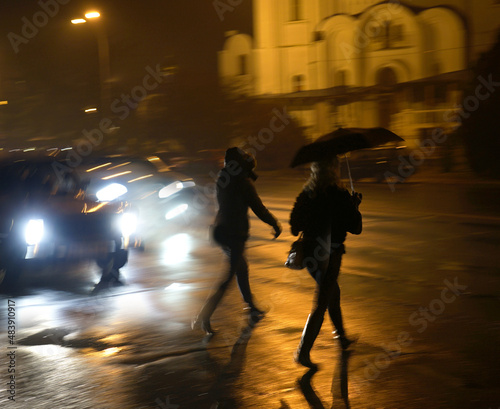 Fototapeta Naklejka Na Ścianę i Meble -  Busy city street people on zebra crossing at night. Dangerous situation