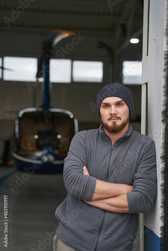 Bearded seriously male looking ahead in hangar