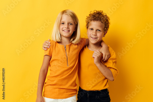 Cute preschool kids casual wear games fun together posing on colored background