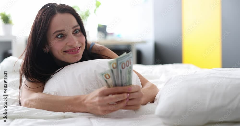 Joyful woman after sleep finds money under pillow closeup Joyful woman after sleep finds money under pillow closeup