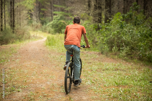 happy teen boy riding a bike on natural background, forest or park. healthy lifestyle, family day out