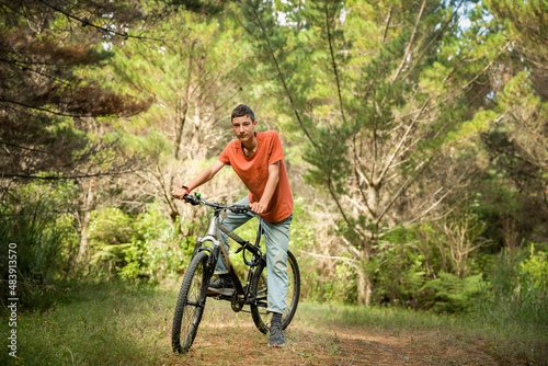 happy teen boy riding a bike on natural background, forest or park. healthy lifestyle, family day out