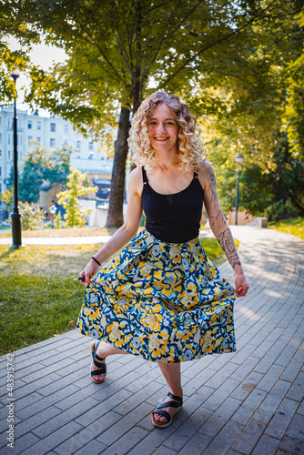 Valokuva Beautiful curly haired woman curtsy in the city park