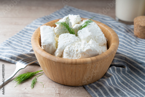 Traditional homemade salted cottage cheese cheese in a wooden bowl