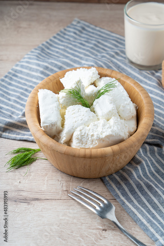 Traditional homemade salted cottage cheese cheese in a wooden bowl