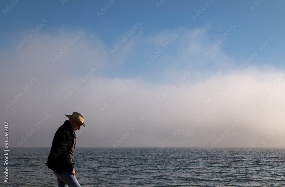 Adult man in cowboy hat and jeans on beach against sea and sky. Almeria, Spain