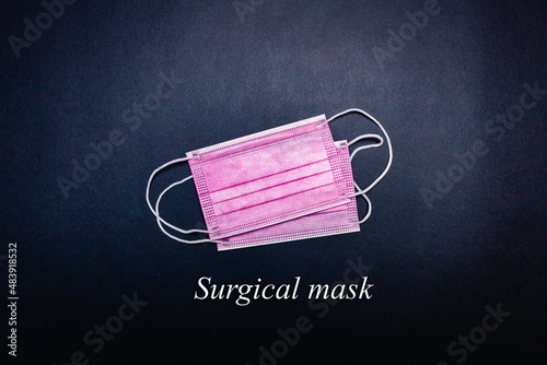 Two pink face masks in the center on a black background with "surgical mask" writing