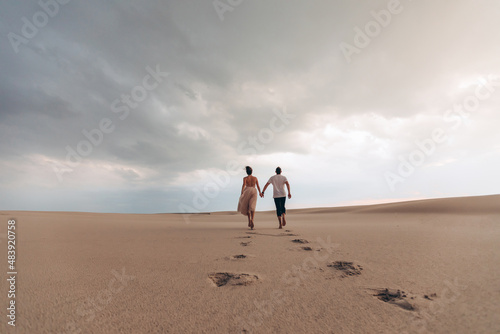 the wedding couple goes into the distance against the backdrop of the desert