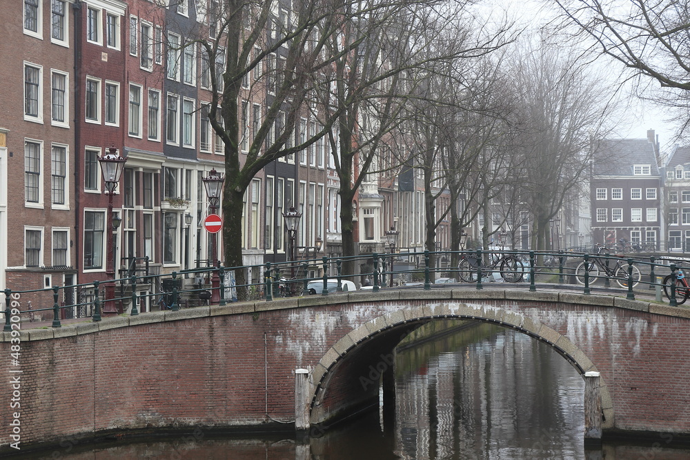 Fototapeta premium Amsterdam Leidsegracht Canal View with Stone Bridge, Parked Bicycles and House Facades, Netherlands