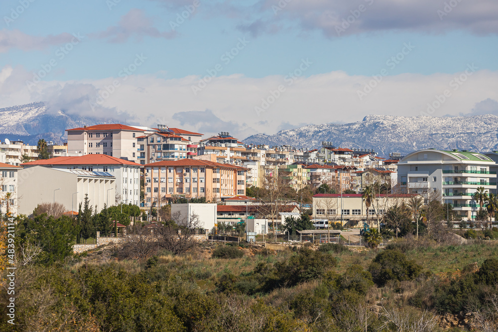 Colorful Turkish streets with low houses, barrels of hot water on the roof and solar panels,  hotels  and mountain on background
