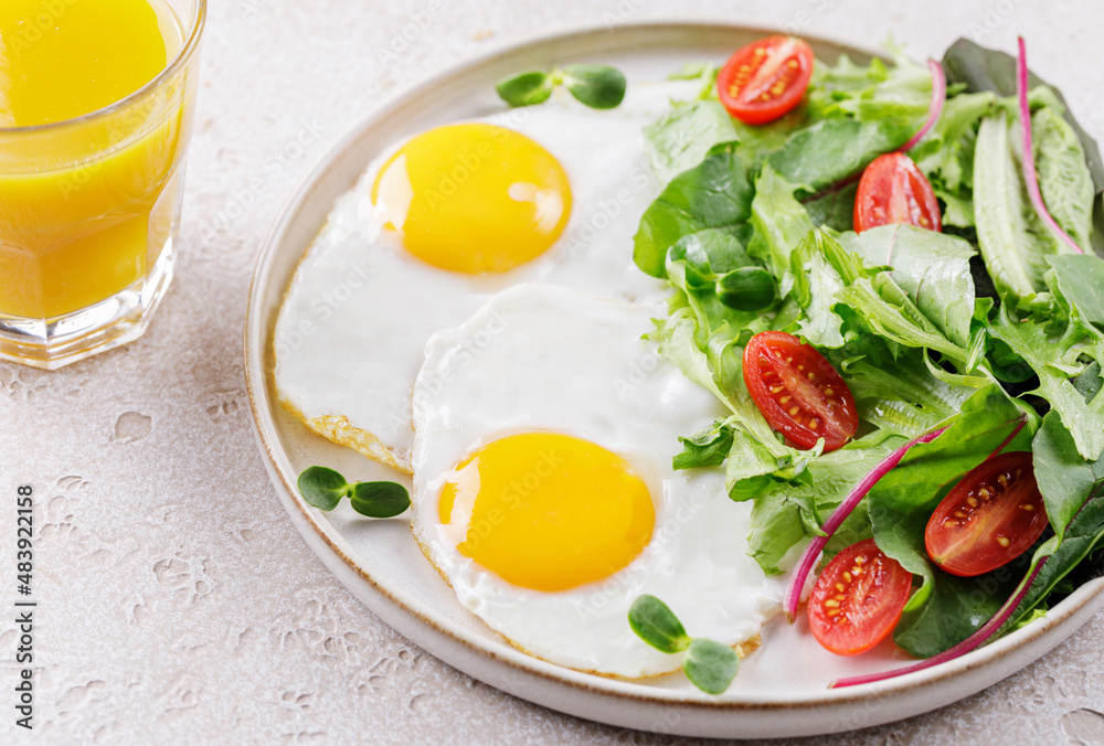 Healthy breakfast with scrambled fried eggs and fresh green salad with organic microgreens and cherry tomatoes. Egg breakfast. Selective focuse. Healthy breakfast with scrambled fried eggs and fresh green salad with organic microgreens and cherry tomatoes. Egg breakfast. Selective focuse.