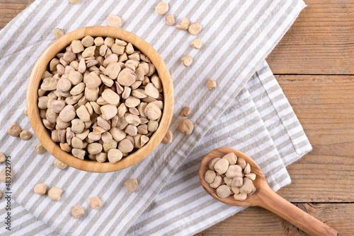 Cicerchia or indian pea in a bowl with napkin on natural wooden background, gluten free food. Legumes known as Lathyrus Sativus, Chickling Vetch, Blue Sweet Pea made in Puglia, top view photo