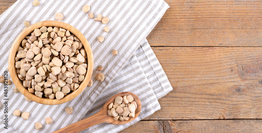 Cicerchia or indian pea in a bowl with napkin on natural wooden background, gluten free food. Legumes known as Lathyrus Sativus, Chickling Vetch, Blue Sweet Pea made in Puglia, top view. banner Cicerchia or indian pea in a bowl with napkin on natural wooden background, gluten free food. Legumes known as Lathyrus Sativus, Chickling Vetch, Blue Sweet Pea made in Puglia, top view. banner