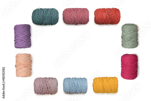 Frame of colorful macrame yarns isolated on white background. Natural cotton macrame yarn rolls on white photo