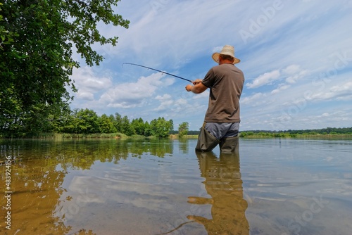 angler catching the fish during summer day