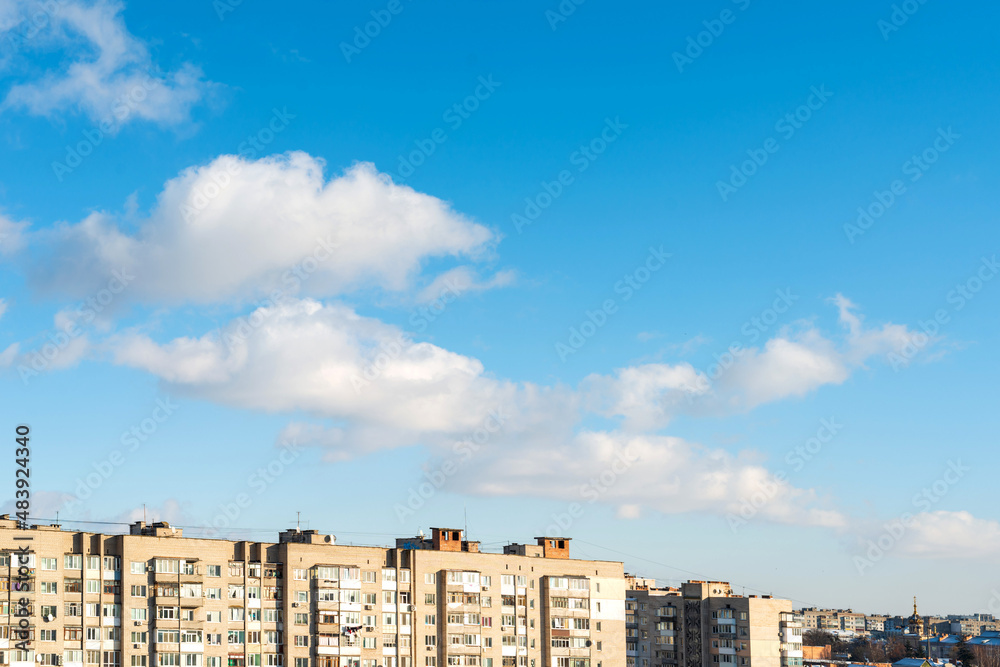 City houses on a background of clouds and blue sky