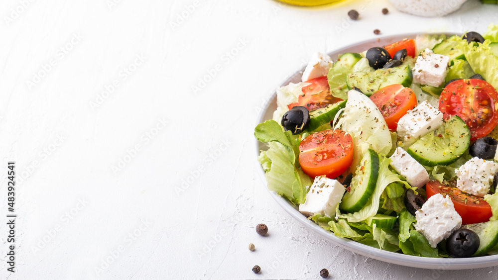 Healthy salad with cherry tomatoes, cucumber, lettuce and cheese. Diet food concept. Copy space