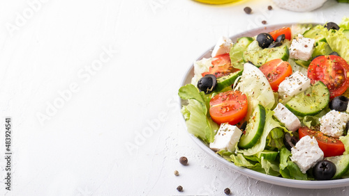 Healthy salad with cherry tomatoes, cucumber, lettuce and cheese. Diet food concept. Copy space