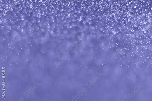 Very peri color of the year 2022, violet sparkling glitter bokeh background, christmas abstract defocused texture. Holiday lights