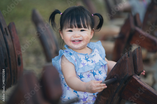 Happy cute baby playing on rocking horse in the park. 1 year 6 month baby in the park use as concept of play, health, mood and motion of baby and kid development. photo