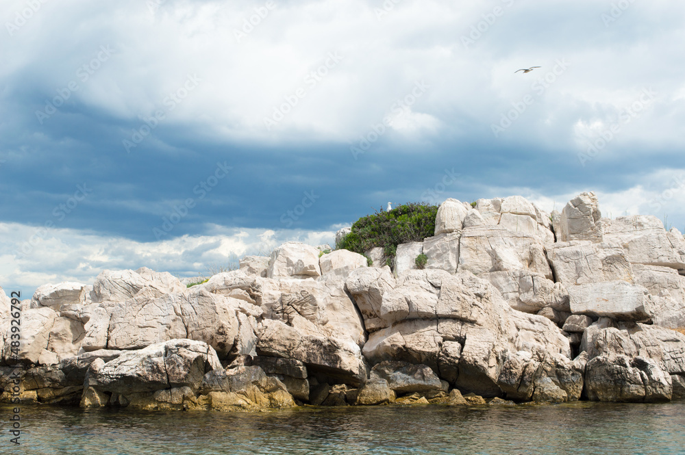 Small isolated rocky islet with seagulls in Adriatic sea, Croatia, Zadar region Small isolated rocky islet with seagulls in Adriatic sea, Croatia, Zadar region
