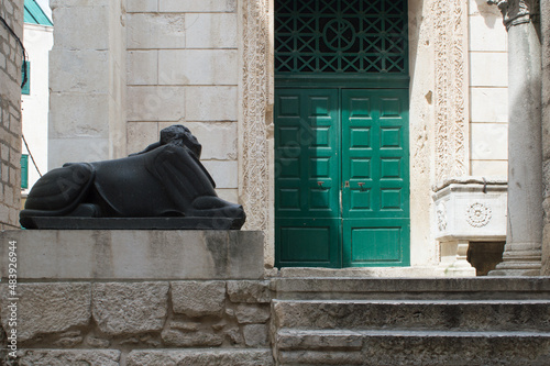 Front gate of the temple of Jupiter in the Diocletian's Palace in Split, Croatia, beautiful restored historic building with green door and guarded by Egyptian sphinx photo