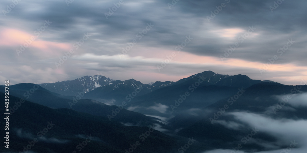 The setting sun illuminates the clouds over the mountain peaks of the caucasus The setting sun illuminates the clouds over the mountain peaks of the caucasus