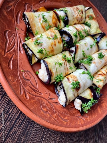 large vertical photo. homemade food. fried eggplant rolls with creamy sauce. top-down view. organic products.
