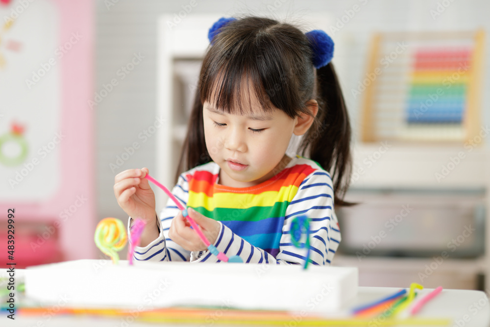 young girl threading beads making craft for home schooling young girl threading beads making craft for home schooling