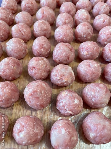 large vertical photo. healthy wholesome homemade food. raw chicken mince preparation. meatballs on a wooden board close-up. children's diet. eco.