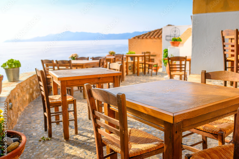 Sunny scene Traditional outdoor cafe in a Greek resort. summertime in mediterranean. famous travel destination