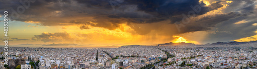 Panorama of the Greek capital Athens at sunset with a sky overcast with thunderclouds, Greece, Europe. View of the city from above