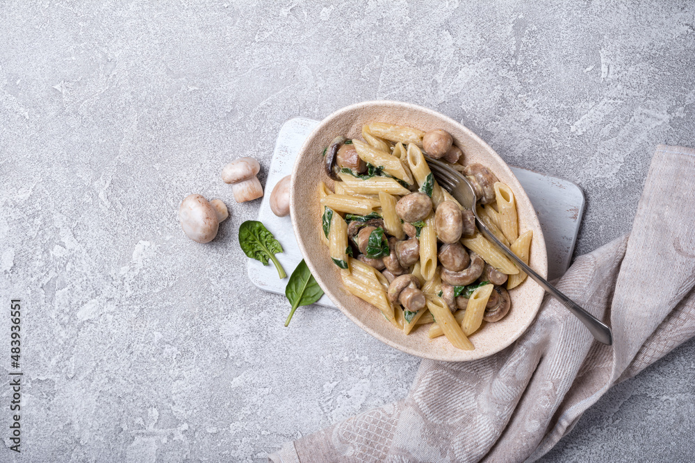 Bowl of pasta and mushrooms in cream sauce with spinach Bowl of pasta and mushrooms in cream sauce with spinach