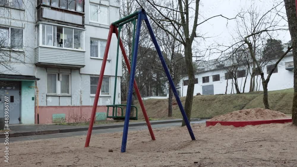 A lone swing swings in the wind at an unknown playground in a depressing backyard of an Eastern European ghetto. Concept of kidnapping, bullying. High quality 4k footage A lone swing swings in the wind at an unknown playground in a depressing backyard of an Eastern European ghetto. Concept of kidnapping, bullying. High quality 4k footage