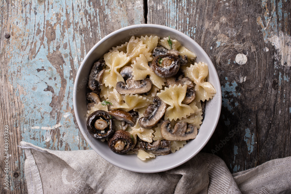 Bowl of italian farfalle pasta and mushrooms with cream sauce Bowl of italian farfalle pasta and mushrooms with cream sauce