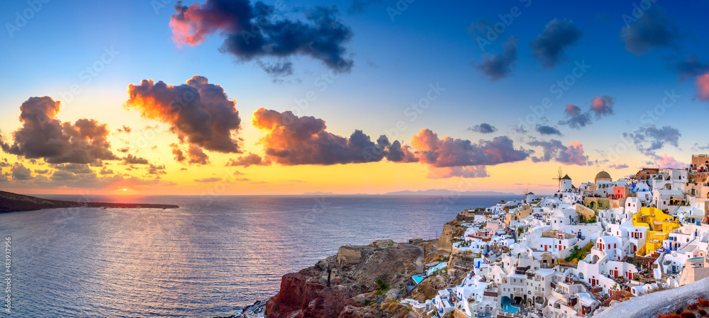 Naklejka premium Picturesque sunset on famous view resort over Oia town on Santorini island, Greece, Europe. luxury travel. famous travel landscape. Summer holidays. Travel concept background.