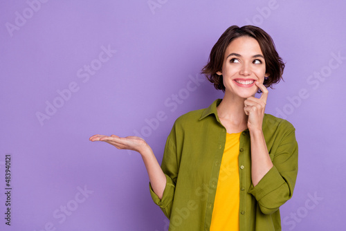 Photo of young cheerful woman curious look empty space ads decision discount recommend isolated over violet color background photo