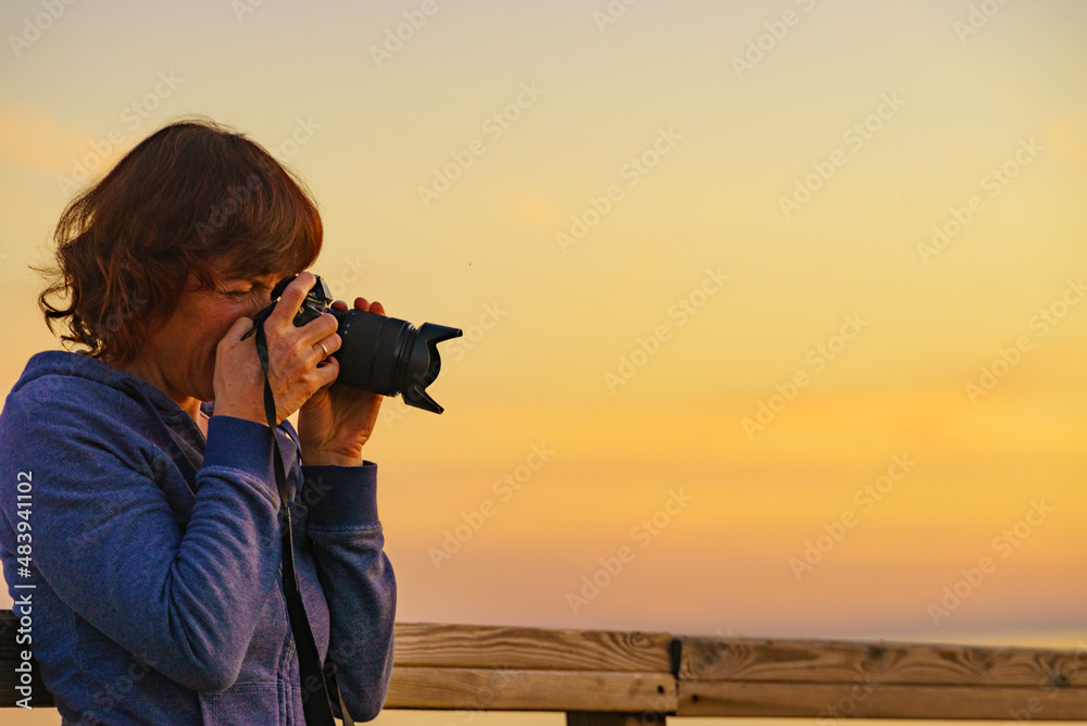 Woman with camera take travel photo at sunset Woman with camera take travel photo at sunset